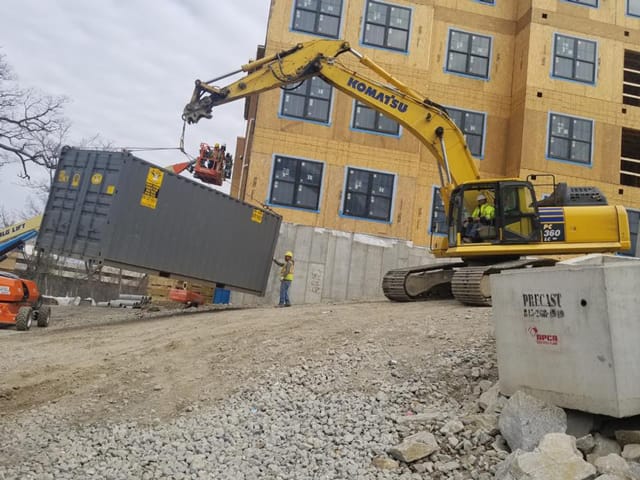 40ft Storage Container being carried by excavator