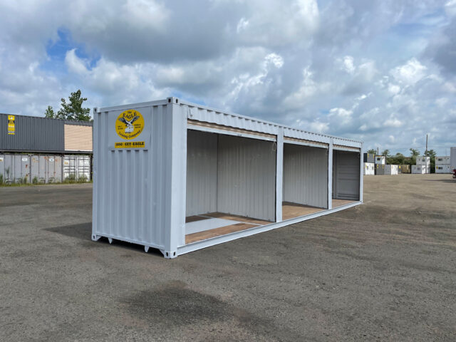 Storage container with three roll-up doors and internal dividers.
